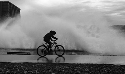 Cyclist going through a wave of water